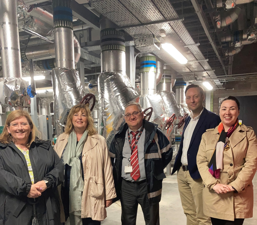 A group of people pose for a photograph at a district heating facility.